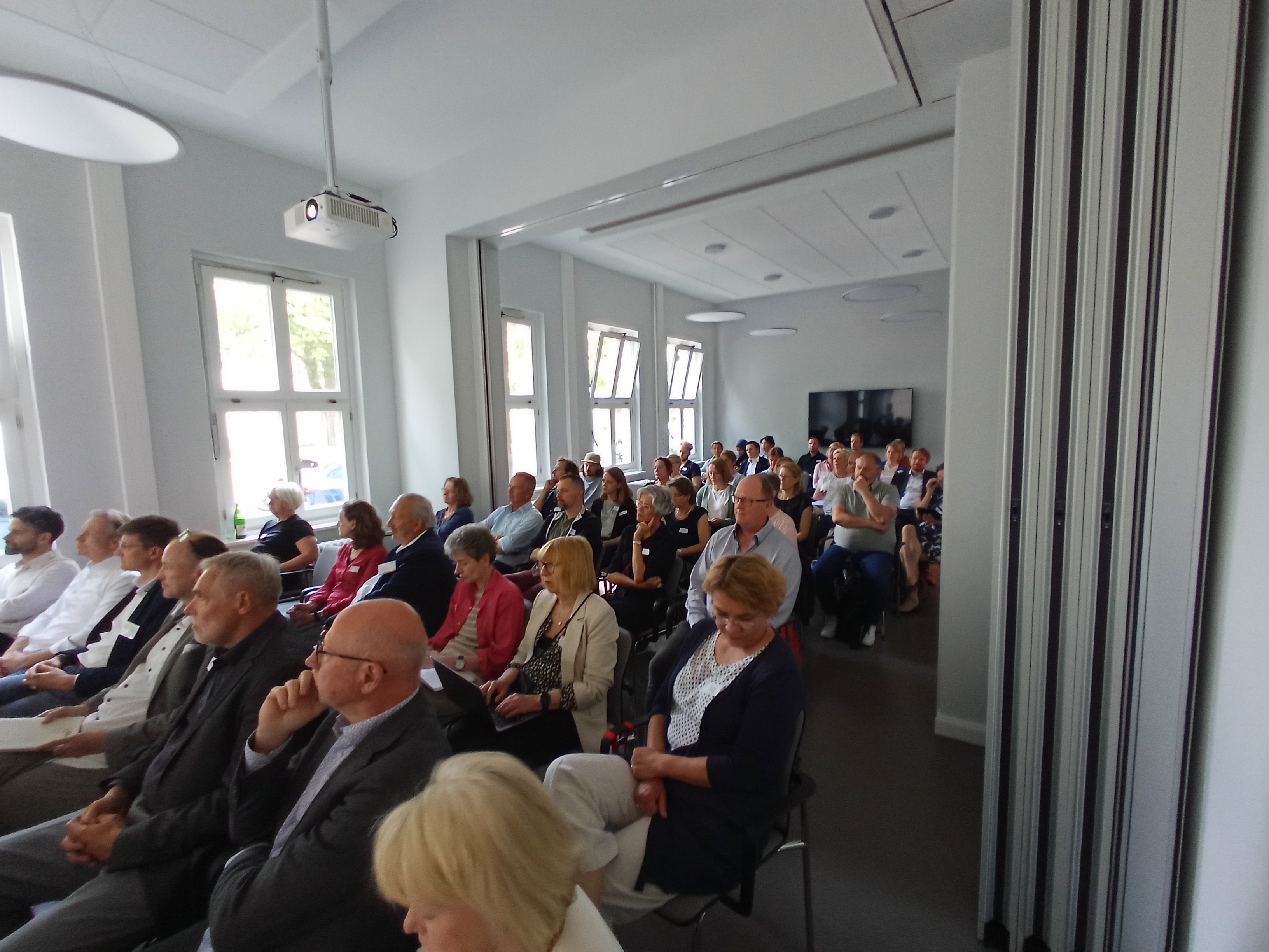 Das Bild zeigt den Veranstaltungsraum im Haus für Barrierefreiheit mit zahlreichen Teilnehmerinnen und Teilnehmer einer Projektveranstaltung.