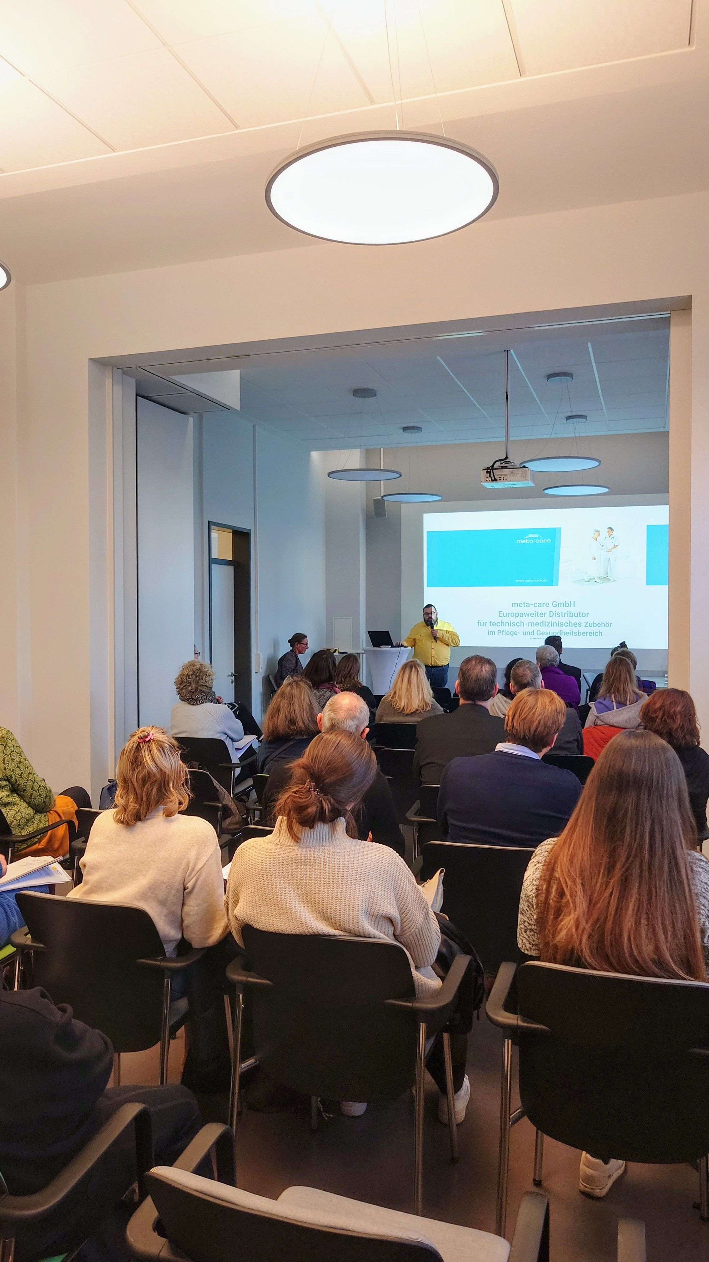  Vortragsraum mit Personen, die einem Redner zuhören